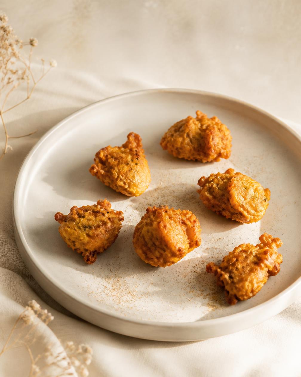Golden crisp snack pieces on a pale ceramic plate